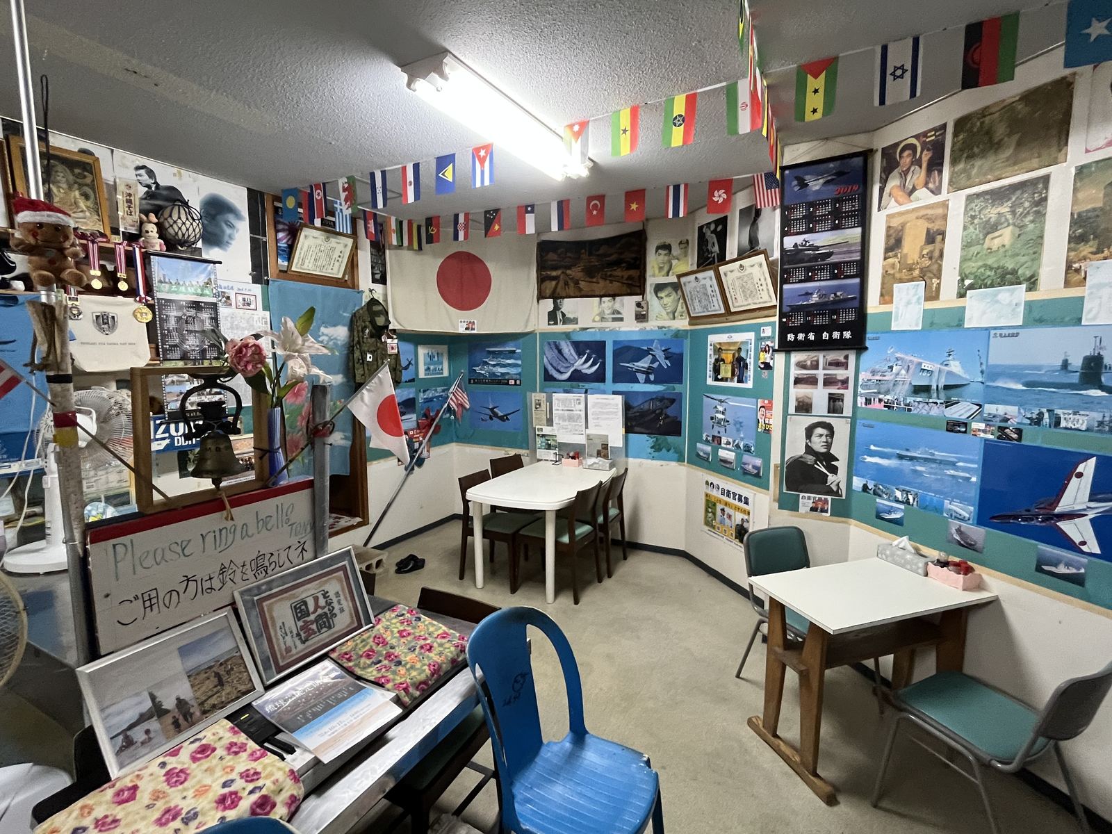 国旗や自衛隊のポスターが壁一面に貼られた栄福食堂の店内