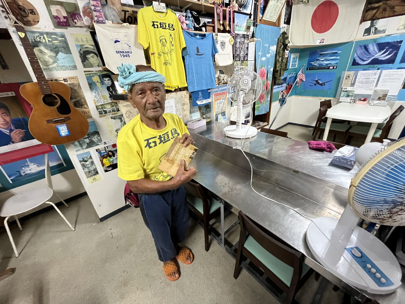 椎名誠さんの本を手に持つ栄福食堂の店主
